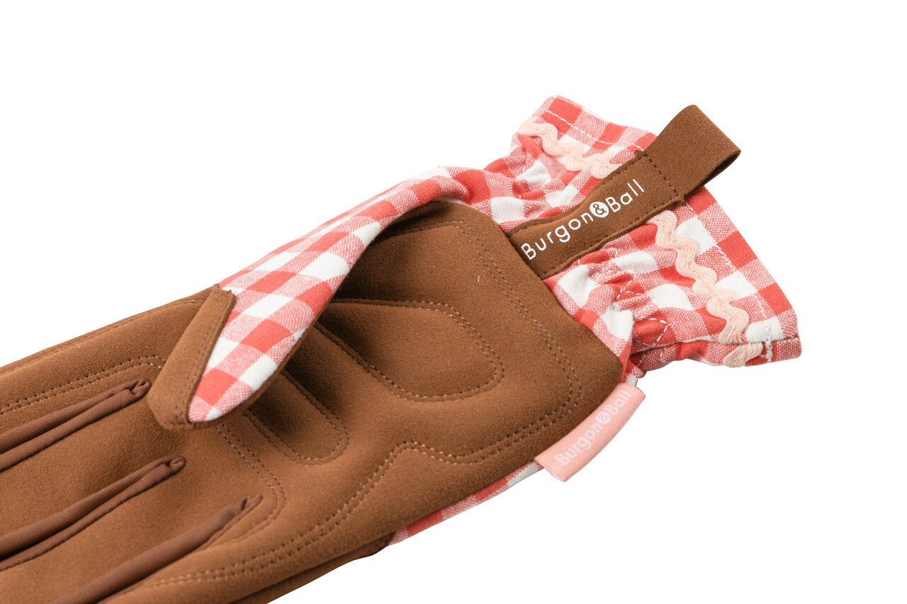 Die Handfläche der rot karierten Gartenhandschuhe