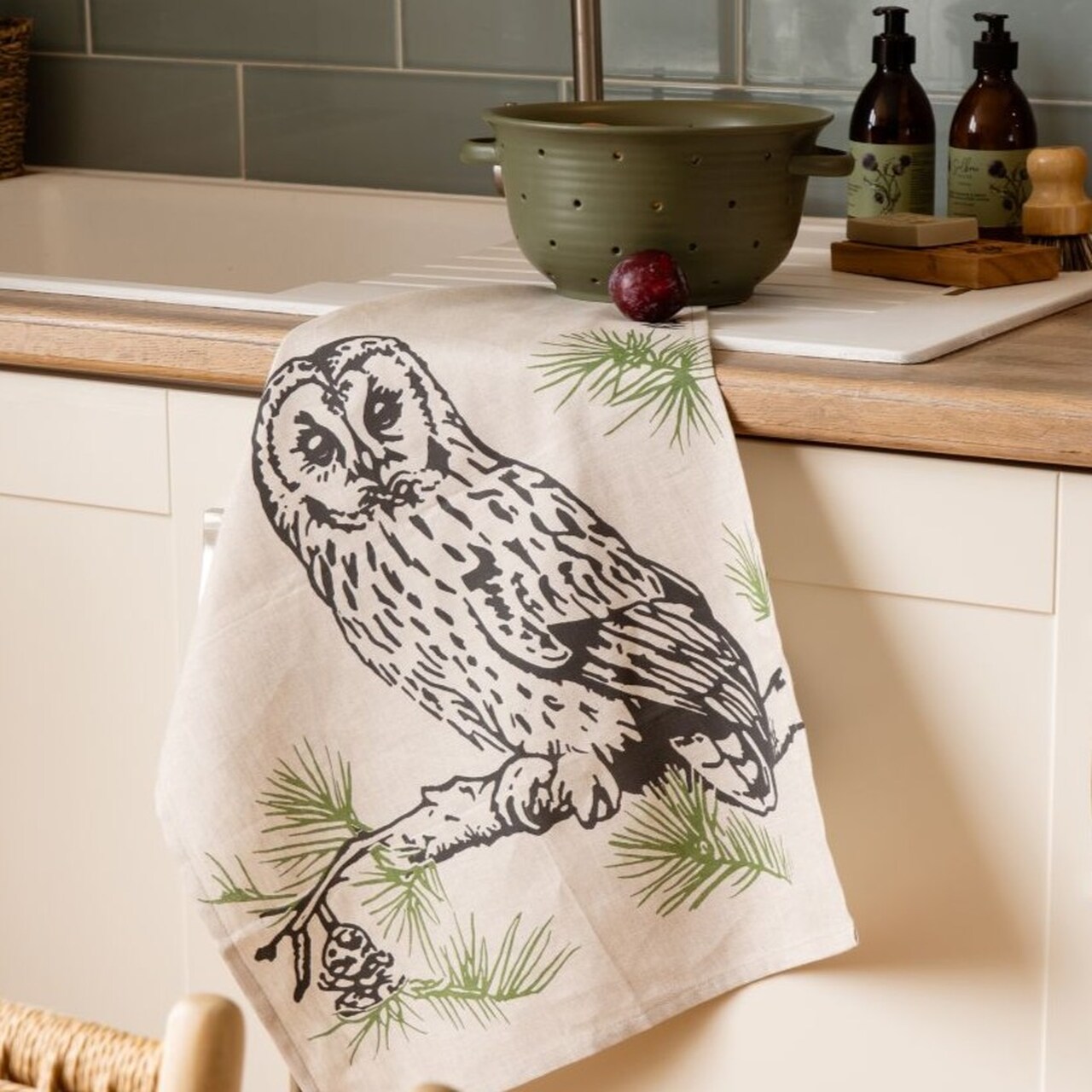 Leinen-Geschirrtuch Tawny Owl - Waldkauz | In Schottland die Hüterin verborgener Wahrheiten und der Magie | Dezent zweifarbig illustriert  auf einem Zweig mit grünen Nadeln sitzend | von Selbrae House, Schottland.