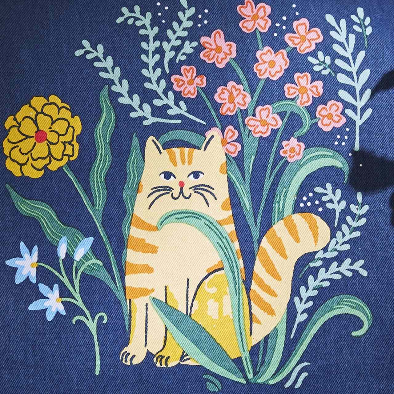 Nahaufnahme des Designs | die orangerote Katze auf Dunkelblau inmitten von Wiesenblumen.